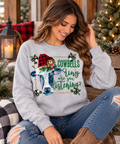 Model wearing Heather Gray Cowbells Ring Christmas sweatshirt in rustic holiday setting