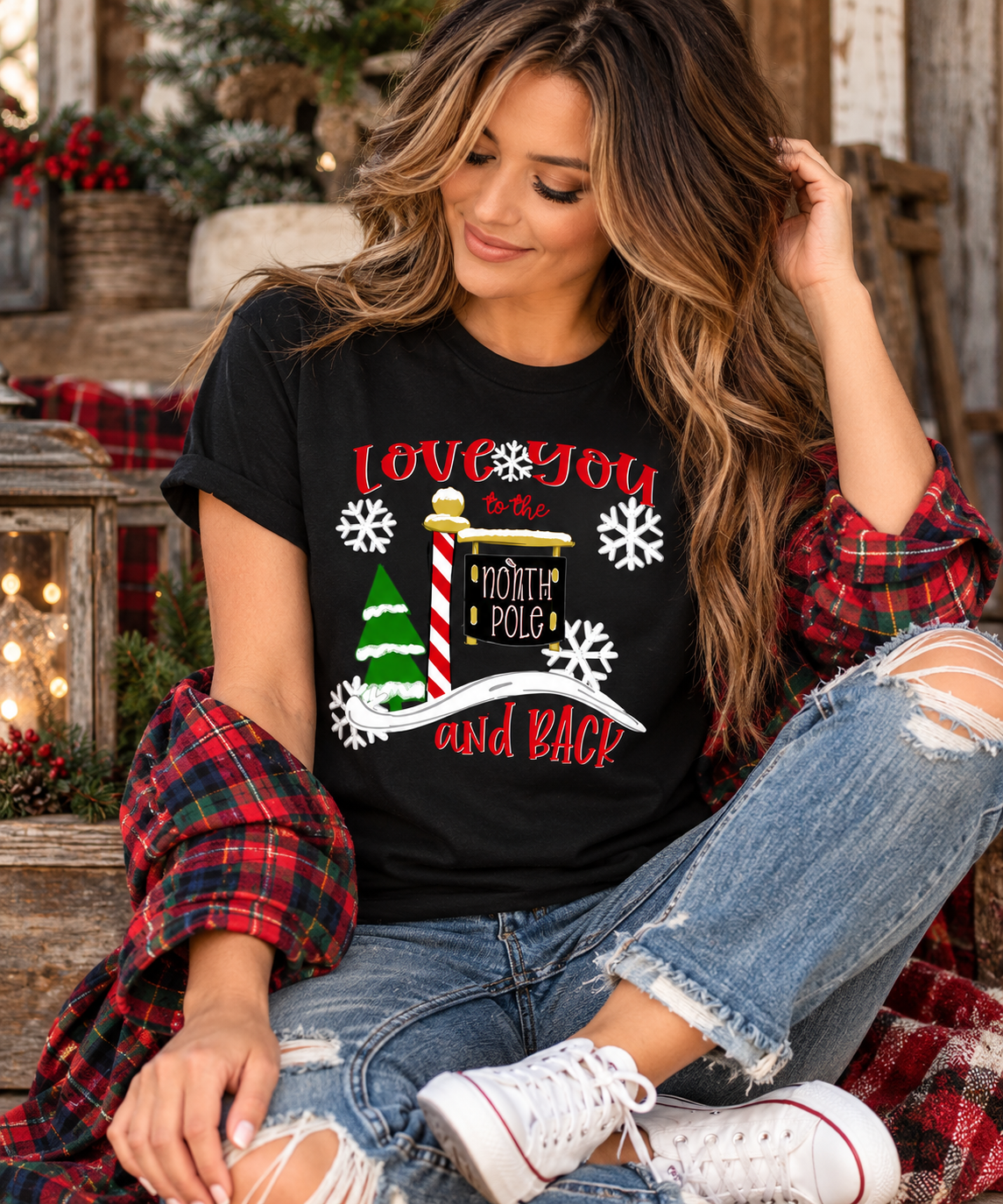 Model wearing Love You to the North Pole and Back black Christmas tee with plaid flannel and jeans