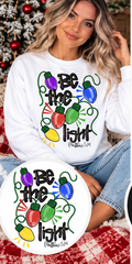 Be the Light – White Christmas Sweatshirt approved model mockup with circular design inset